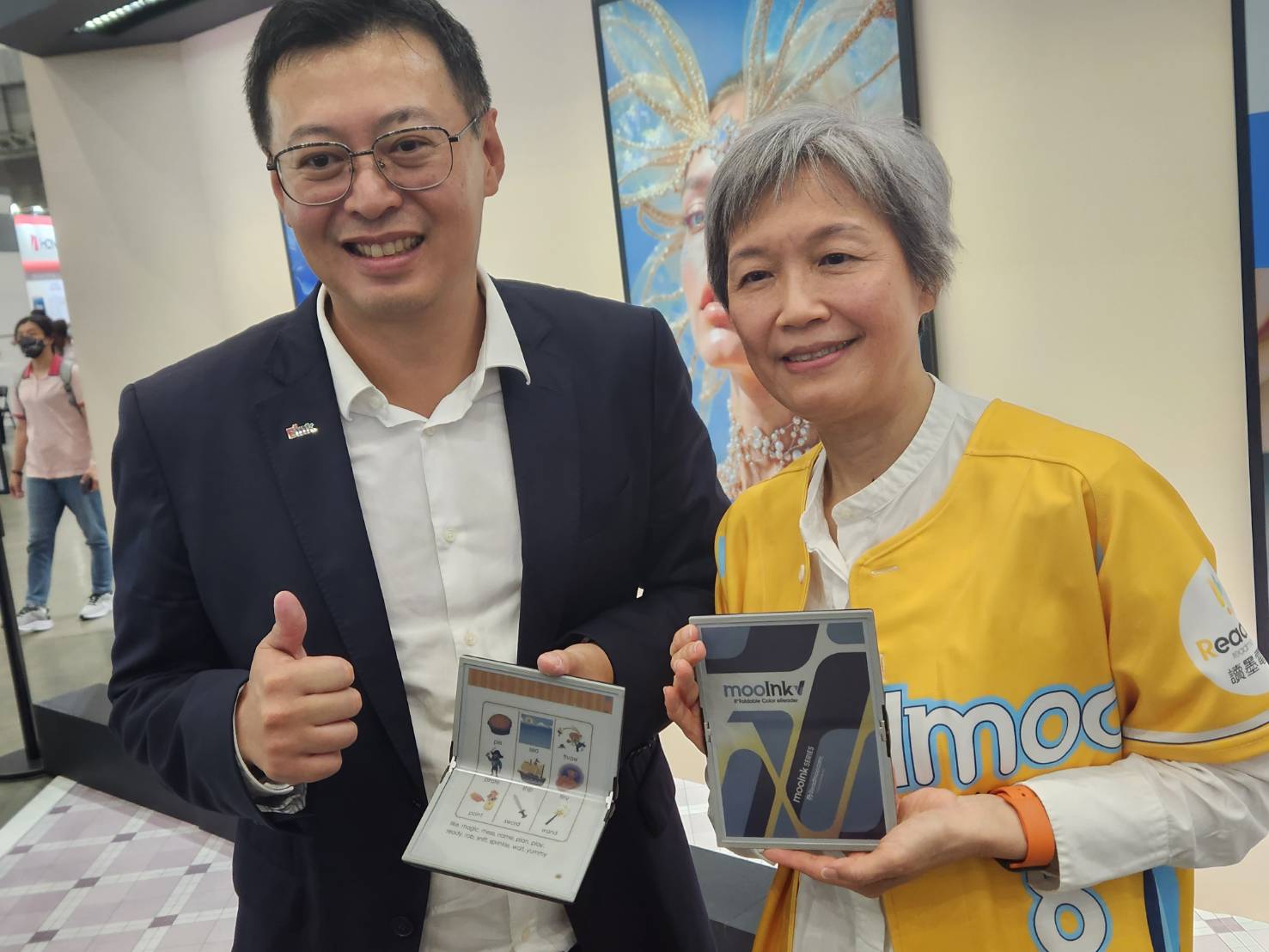 Readmoo讀墨電子書執行長龐文章(右) 16日偕同E Ink元太科技董事長李政昊(左)，聯手發表全球首款折疊彩色電子書閱讀器mookInk V，輕薄可放口袋，造型也具有時尚感。(江昭倫 攝)