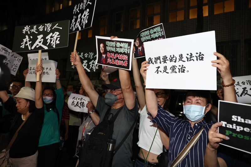 國民黨主席朱立倫17日號召黨公職及群眾晚間到北檢外集結，許多支持者到場參與，在北檢外高舉標語。 (圖：中央社)