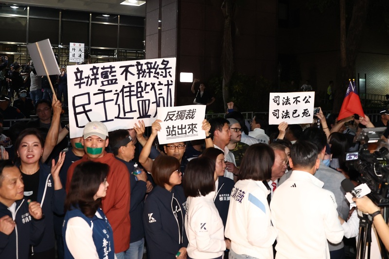 國民黨主席朱立倫17日號召黨公職及群眾赴北檢外抗議司法不公，台北市長蔣萬安晚間到場聲援喊話，發言結束離去時，警方也在後方不遠處持續舉牌警告勸離。(圖：中央社)