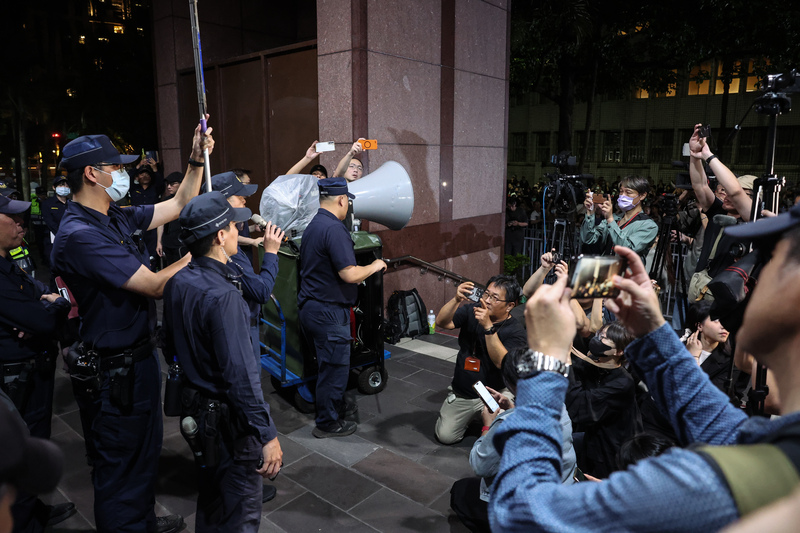 台北地檢署偵辦不實連署案，17日約談國民黨北市黨部主委黃呂錦茹等人，黨中央晚間號召赴北檢外抗議，警方也到場待命、屢次舉牌勸離，並搬出大型大聲公再次進行違法集會警告。(圖：中央社)