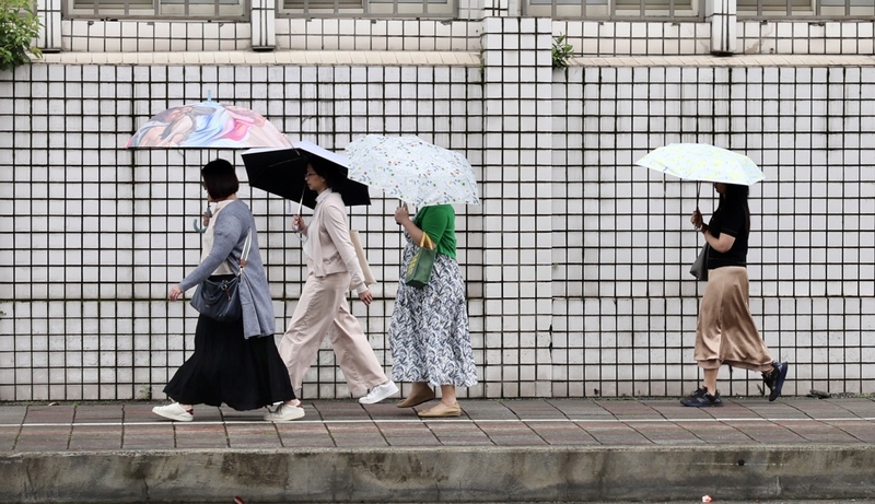 圖為台北市博愛特區民眾街頭撐傘。(圖：中央社)