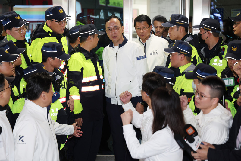 國民黨主席朱立倫（白衣中）26日在凱道集會活動結束後，自行前往台北市警局中正一分局，向警方說明日前北檢非法集會案等，晚間走出警局時，多名立委在外聲援打氣。 (圖：中央社)