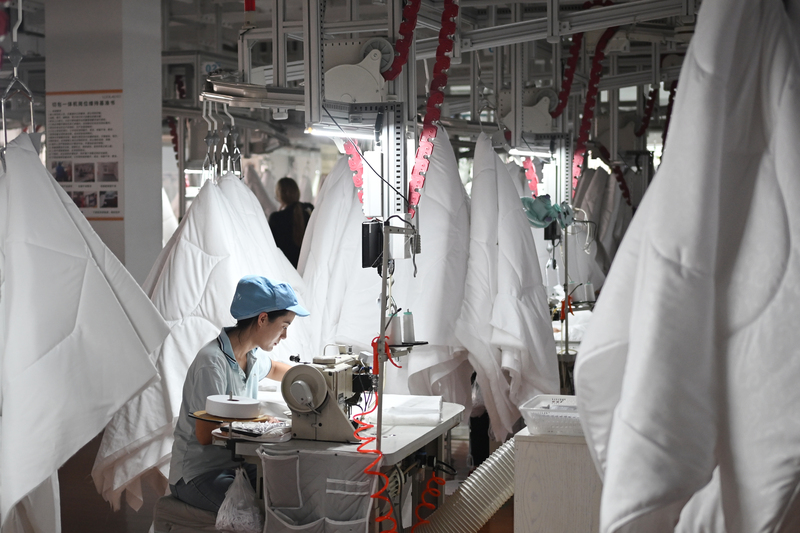受美中關稅戰影響，紡織等行業的中國製造商正在世界各地尋找新客戶，以減少美國客戶流失帶來的影響。圖為江蘇南通經濟技術開發區內，工人在智慧車間加工被子。（中新社提供）中央社  114年4月28日 (圖：中央社)