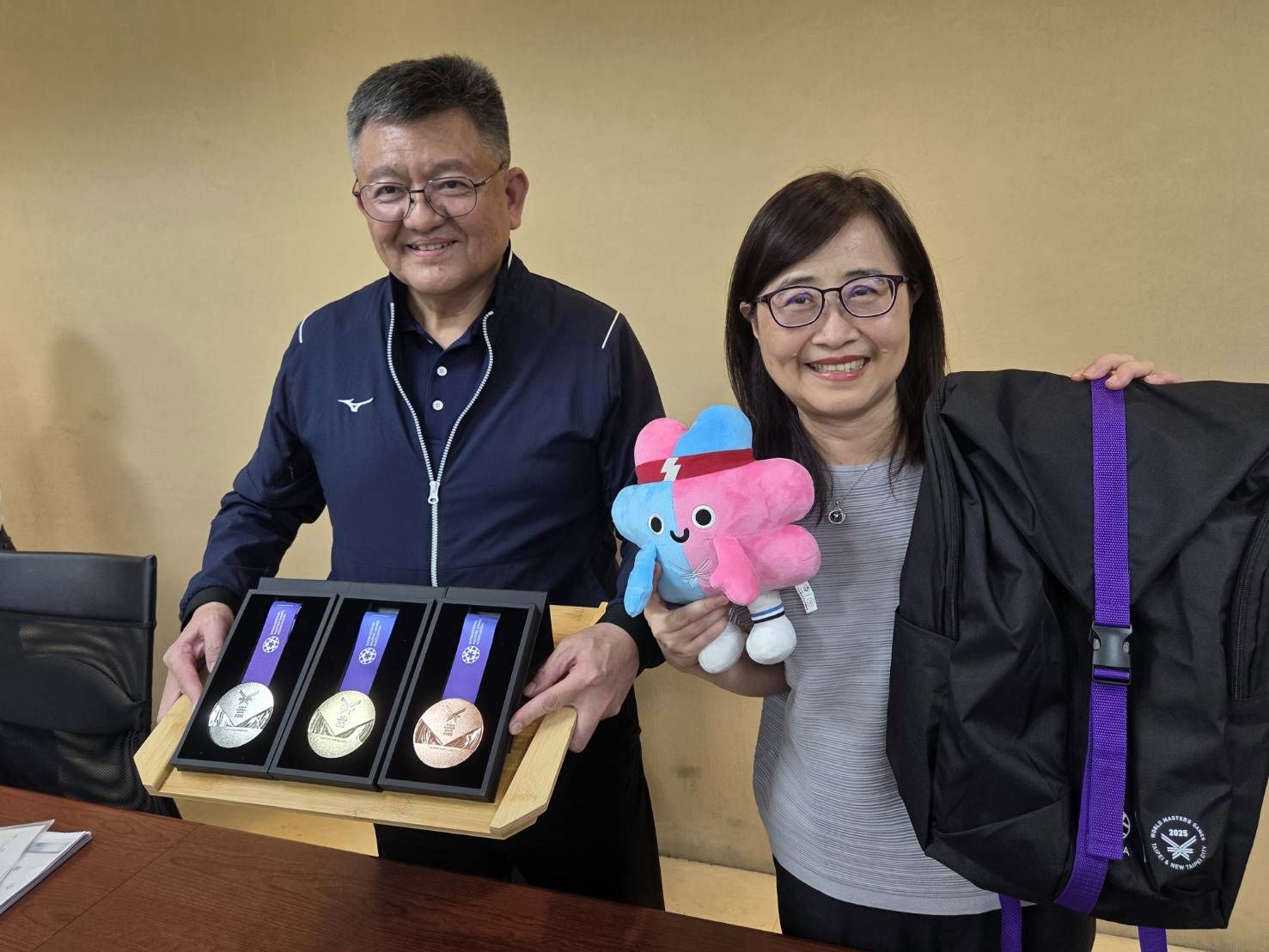 台北市副市長林奕華(右)與雙北世壯運執行長林哲宏(左)介紹2025雙北世壯運選手禮包與獎牌設計。(江昭倫 攝)