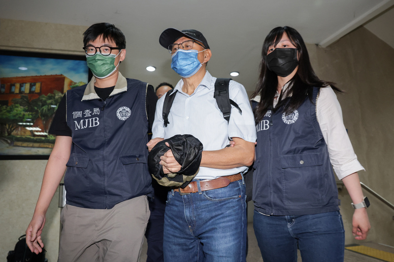 台北地檢署偵辦國民黨立委傅崐萁競選小物案，通緝中的被告李慶隆（中）9日主動向檢調投案。 (圖：中央社)