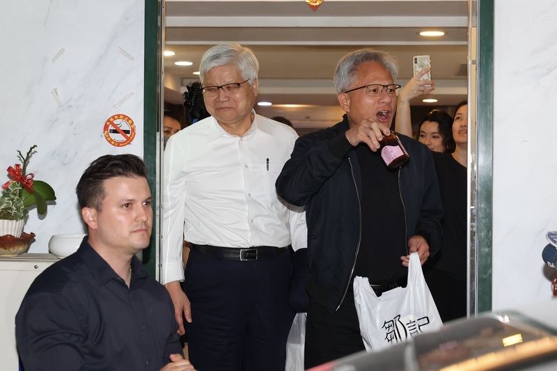 輝達(NVIDIA)執行長黃仁勳(右)16日抵台後，晚間率先與台積電董事長暨總裁魏哲家(左2)在台北共進晚餐，離開時黃仁勳特別秀出他在餐廳購買的產品。(圖：中央社)