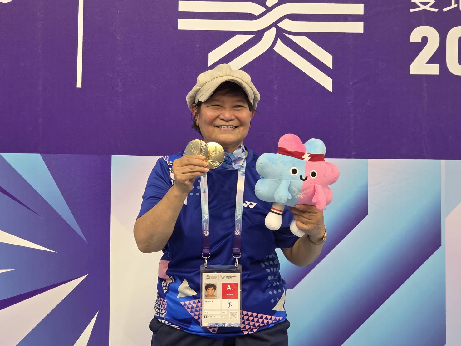 71歲羽球名將林說世壯運奪雙金，站上頒獎台時笑容滿面。(江昭倫 攝)